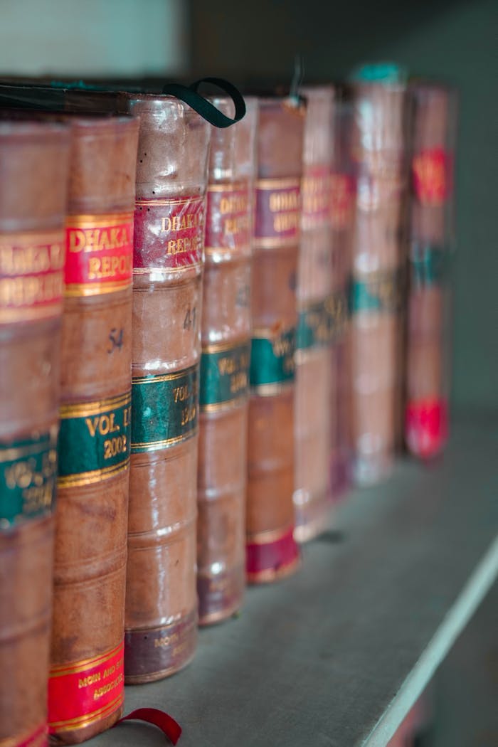Close-up of leather-bound law books arranged neatly on a bookshelf, showcasing traditional literature.
